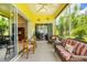 Inviting screened-in patio with comfortable seating, ceiling fan, and view to a well-manicured backyard at 2085 Mattamy Ct, Venice, FL 34292
