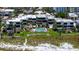 Aerial view of condos with pool and lawn leading to sandy beach, surrounded by tropical palms at 222 Beach Rd # 7, Sarasota, FL 34242