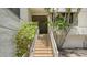 Condo entrance with tiled stairs, lush landscaping, and a secure door at 222 Beach Rd # 7, Sarasota, FL 34242
