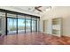 Bright living room with hexagonal tile floors, sliding glass doors to a beachfront balcony, and built-in bookshelves at 222 Beach Rd # 7, Sarasota, FL 34242