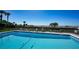 Community pool featuring lounge chairs, palm trees, and views of the ocean at 222 Beach Rd # 7, Sarasota, FL 34242
