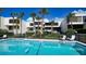 Community pool with lounge chairs, surrounded by palm trees and lush landscaping at 222 Beach Rd # 7, Sarasota, FL 34242