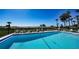 Community pool featuring lounge chairs, palm trees, and blue ocean views at 222 Beach Rd # 7, Sarasota, FL 34242