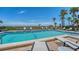 Community pool featuring lounge chairs, palm trees, and ocean views at 222 Beach Rd # 7, Sarasota, FL 34242
