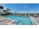 Community pool featuring lounge chairs, palm trees, and views of the white sand beach at 222 Beach Rd # 7, Sarasota, FL 34242