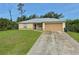 Charming single-story home with well-maintained lawn and a long concrete driveway at 2403 Trianna St, North Port, FL 34291