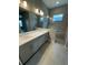 Luxurious bathroom featuring double sinks, tiled walk-in shower, and bright modern lighting at 24827 Buckingham Way, Port Charlotte, FL 33980