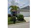 Charming single-story home with a well-maintained lawn, palm trees, and a two-car garage at 24827 Buckingham Way, Port Charlotte, FL 33980