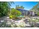 A picturesque backyard featuring a screened-in pool area surrounded by lush greenery and a blue sky at 2515 Huntington Ave, Sarasota, FL 34232