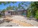 A backyard view featuring stone landscaping and a screened-in pool area surrounded by lush greenery at 2515 Huntington Ave, Sarasota, FL 34232