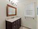Bathroom with a granite countertop, new cabinet, and framed mirror at 2515 Huntington Ave, Sarasota, FL 34232