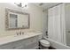 Well-lit bathroom featuring a decorative mirror, marble countertop, and bathtub with a shower and white curtain at 2515 Huntington Ave, Sarasota, FL 34232