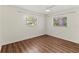 Bright bedroom featuring two windows and wood-look flooring, offering natural light and a cozy atmosphere at 2515 Huntington Ave, Sarasota, FL 34232