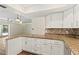 Bright kitchen with granite countertops, white cabinets, and an adjacent living area at 2515 Huntington Ave, Sarasota, FL 34232