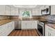 Modern kitchen boasting stainless steel appliances, granite counters, and mosaic tile backsplash at 2515 Huntington Ave, Sarasota, FL 34232