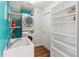 A modern laundry room featuring stacked washer and dryer, a utility sink, and ample shelving at 2515 Huntington Ave, Sarasota, FL 34232