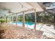 A screened-in pool and paved patio, offering a luxurious outdoor living space with tropical accents at 2515 Huntington Ave, Sarasota, FL 34232