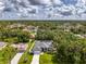 Beautiful aerial view of a charming home with a screened-in pool nestled among lush trees and landscaping at 2546 Malibu Ln, North Port, FL 34286