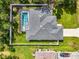 An aerial view shows the roof, pool, backyard and white perimeter fence at 2546 Malibu Ln, North Port, FL 34286