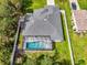 An aerial view displays the house roof, screened pool, yard and white perimeter fence at 2546 Malibu Ln, North Port, FL 34286