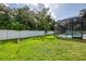 Sprawling backyard with lush green grass and a white fence surrounding the outdoor pool area at 2546 Malibu Ln, North Port, FL 34286