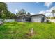 Expansive backyard showcases lush green grass, white perimeter fence, screened pool, and exterior of the home at 2546 Malibu Ln, North Port, FL 34286