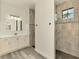 Bright bathroom showcases tiled shower, sleek cabinets, marble counters, modern lighting, and wood floors at 2546 Malibu Ln, North Port, FL 34286