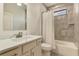This renovated bathroom includes modern gray tiling, a marble vanity, and a bathtub at 2546 Malibu Ln, North Port, FL 34286
