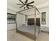 Well-lit bedroom features a tray ceiling, ceiling fan, and a modern four-poster bed frame at 2546 Malibu Ln, North Port, FL 34286