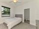 Bright bedroom has modern ceiling fan, window, gray headboard, and connecting bathroom at 2546 Malibu Ln, North Port, FL 34286