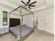 Bright bedroom features a tray ceiling, modern ceiling fan, and view to connecting bathroom at 2546 Malibu Ln, North Port, FL 34286