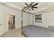 Bright bedroom with modern four-poster bed frame, ceiling fan, and a view to an adjoining room at 2546 Malibu Ln, North Port, FL 34286