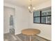 Bright dining area features a modern chandelier, wood-look floors, and a window for natural light at 2546 Malibu Ln, North Port, FL 34286