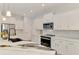 Bright kitchen with white cabinetry, stainless appliances, and marble countertops and backsplash at 2546 Malibu Ln, North Port, FL 34286