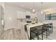 Bright kitchen showcasing white cabinets, a marble island with bar stools, and stainless steel appliances at 2546 Malibu Ln, North Port, FL 34286