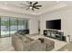 Inviting living room featuring a comfortable sofa, large screen TV, and access to the pool area at 2546 Malibu Ln, North Port, FL 34286