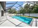 This screened in pool and patio area features clean concrete, dark brick detail, and a manicured lawn at 2546 Malibu Ln, North Port, FL 34286