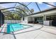 A beautiful screened in pool features a large deck, covered seating, and outdoor kitchen space at 2546 Malibu Ln, North Port, FL 34286