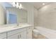 Well-lit bathroom with marble-style tile, white vanity, and a combined tub and shower at 317 Via Tuscany Ave, Sarasota, FL 34243