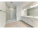 Luxurious bathroom featuring double sinks, granite countertop, and glass shower with tile surround at 317 Via Tuscany Ave, Sarasota, FL 34243