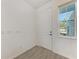 Bright entryway with a white door, window, and light tile flooring at 317 Via Tuscany Ave, Sarasota, FL 34243