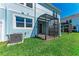 Exterior home view showcasing a screened patio, air conditioning unit, and a manicured lawn at 317 Via Tuscany Ave, Sarasota, FL 34243
