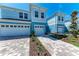 Charming light blue townhouses featuring well-manicured landscaping and brick paver driveways at 317 Via Tuscany Ave, Sarasota, FL 34243