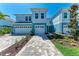 Inviting exterior view of light blue townhouses with brick paver driveways and lush landscaping at 317 Via Tuscany Ave, Sarasota, FL 34243