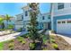 Beautiful townhouses in light blue with lovely landscaped front yards and brick paver walkways at 317 Via Tuscany Ave, Sarasota, FL 34243