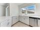 Close up of the kitchen area with stainless steel dishwasher, and light countertops at 317 Via Tuscany Ave, Sarasota, FL 34243