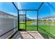 Screened patio with brick flooring and a serene view of the pond and surrounding community at 317 Via Tuscany Ave, Sarasota, FL 34243