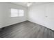 A bright bedroom with new gray flooring, window, and ceiling fan installed at 3222 Sycamore Ter, Sarasota, FL 34237