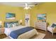 Bright bedroom, painted yellow, featuring coordinated beach-themed décor and a ceiling fan at 3311 39Th W Pl, Bradenton, FL 34205