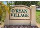 O'Ryan Village community sign with green letters on tan stone and decorative stone landscaping at 3311 39Th W Pl, Bradenton, FL 34205